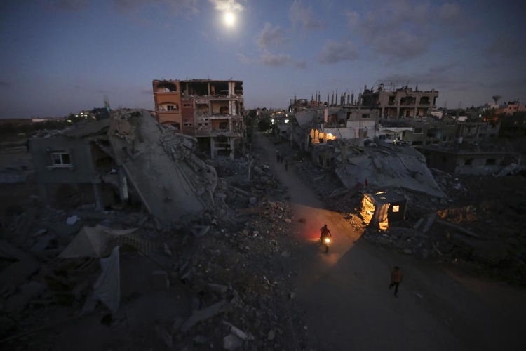 fot. Mohammed Salem / Reuters / 7 września 2014  Beit Hanoun, Palestyna  Palestyńscy piesi i motocykliści przemieszczają się wśród ruin Beit Hanoun.